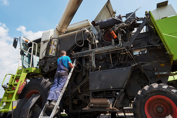 Técnico realiza manutenção em uma máquina agrícola.